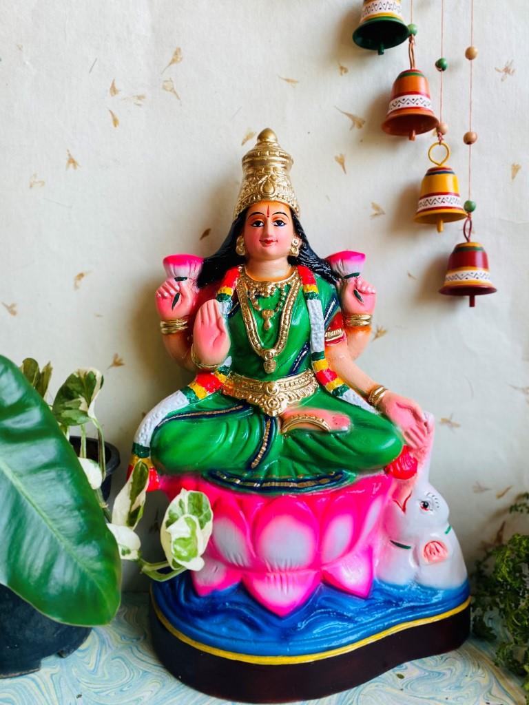 Handcrafted Navaratri Golu Doll of Goddess Lakshmi seated on a pink lotus with vibrant colors and traditional details.