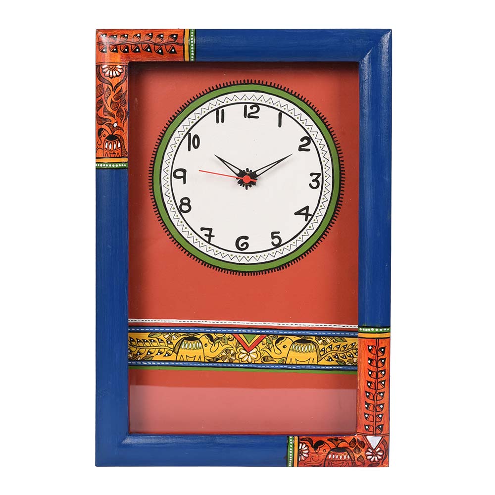 Handcrafted wooden wall clock with Madhubani-inspired folk art, bold blue frame, and vibrant red and orange detailing.
