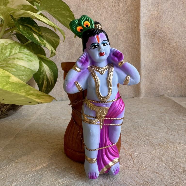 Handcrafted Navarathri Golu doll of Little Krishna tied to a mortar (ural) with vibrant colors and intricate detailing.