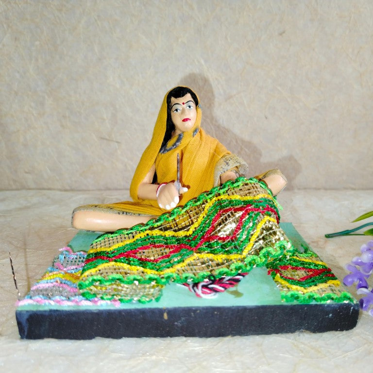 Handcrafted Navarathri Golu doll of a traditional Indian weaver with colorful textile designs and intricate details.