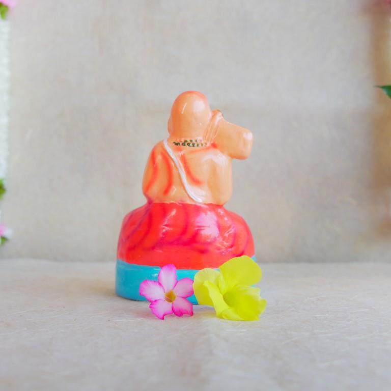 Hand-painted Navarathri Golu doll of Saint Ramanujar in a meditative pose, adorned in vibrant orange and gold attire.
