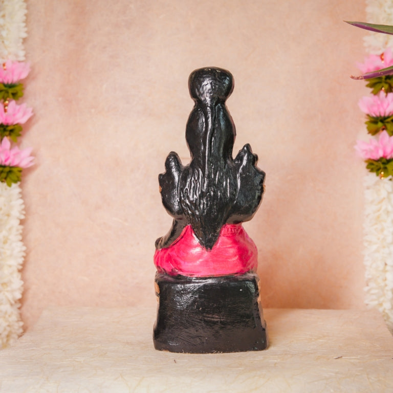 Handcrafted Navarathri Golu doll of Karumari Amman in vibrant pink attire, seated with traditional detailing, adorned with flowers.