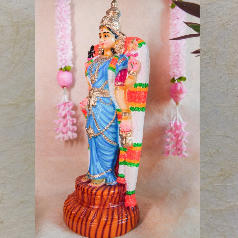 Handcrafted Navarathri Golu doll of Goddess Vishalakshi in a vibrant blue dress, adorned with intricate jewelry and floral garlands.
