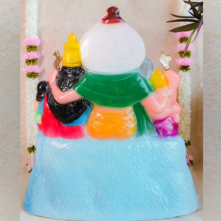 Handcrafted Navarathri Golu doll set depicting the Shiva family, vibrantly painted and adorned with floral decorations.