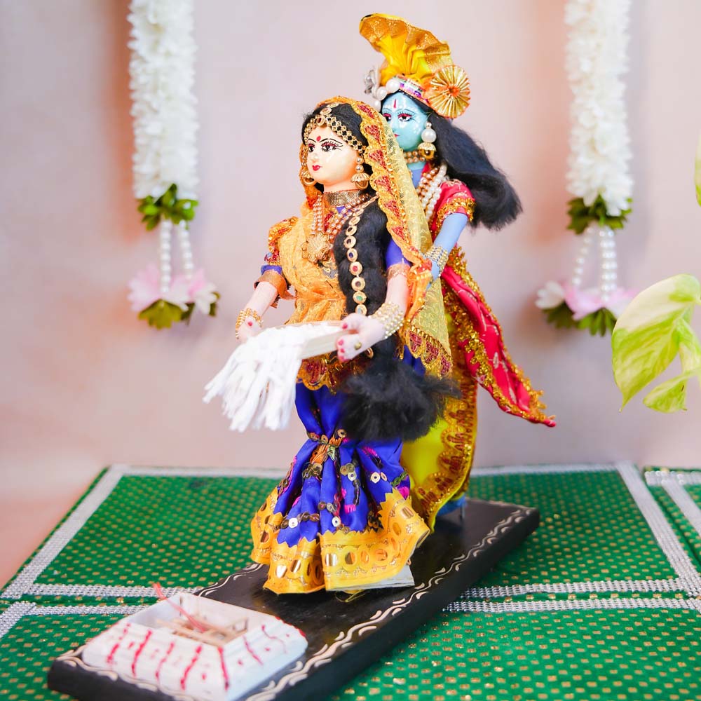 Radha Krishna wedding dolls in traditional attire with intricate detailing, showcasing Indian craftsmanship.