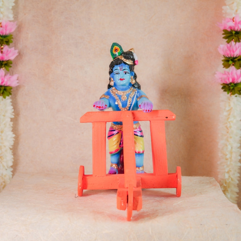 Handcrafted Nadaivandi Krishna idol featuring baby Krishna in blue with traditional ornaments riding a walker for Navaratri Golu.