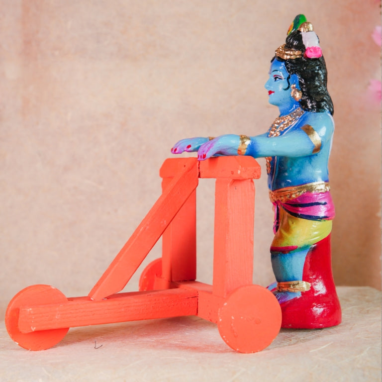 Handcrafted Nadaivandi Krishna idol featuring baby Krishna in blue with traditional ornaments riding a walker for Navaratri Golu.