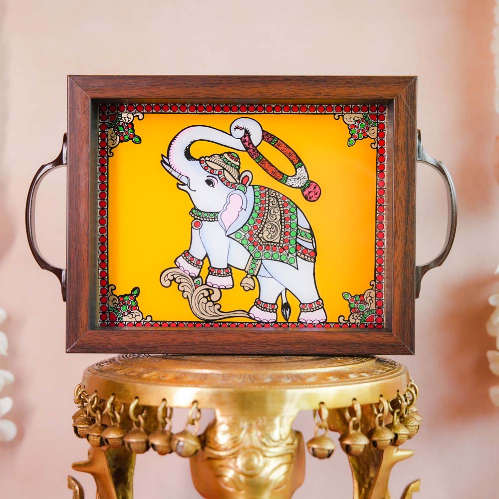 Decorative tray with a hand-painted blessing elephant motif on a vibrant Yellow background, framed with dark wood and metallic handles, displayed on a traditional brass stand.