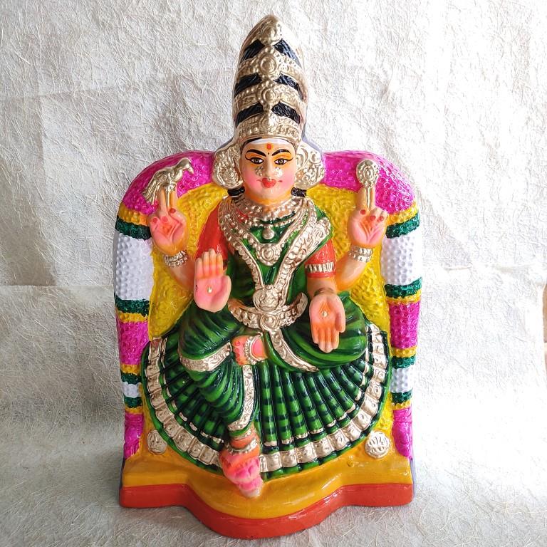 Araikasu Amman Navarathri Golu doll seated under a decorative arch, wearing a green saree with intricate detailing, handcrafted and hand-painted.