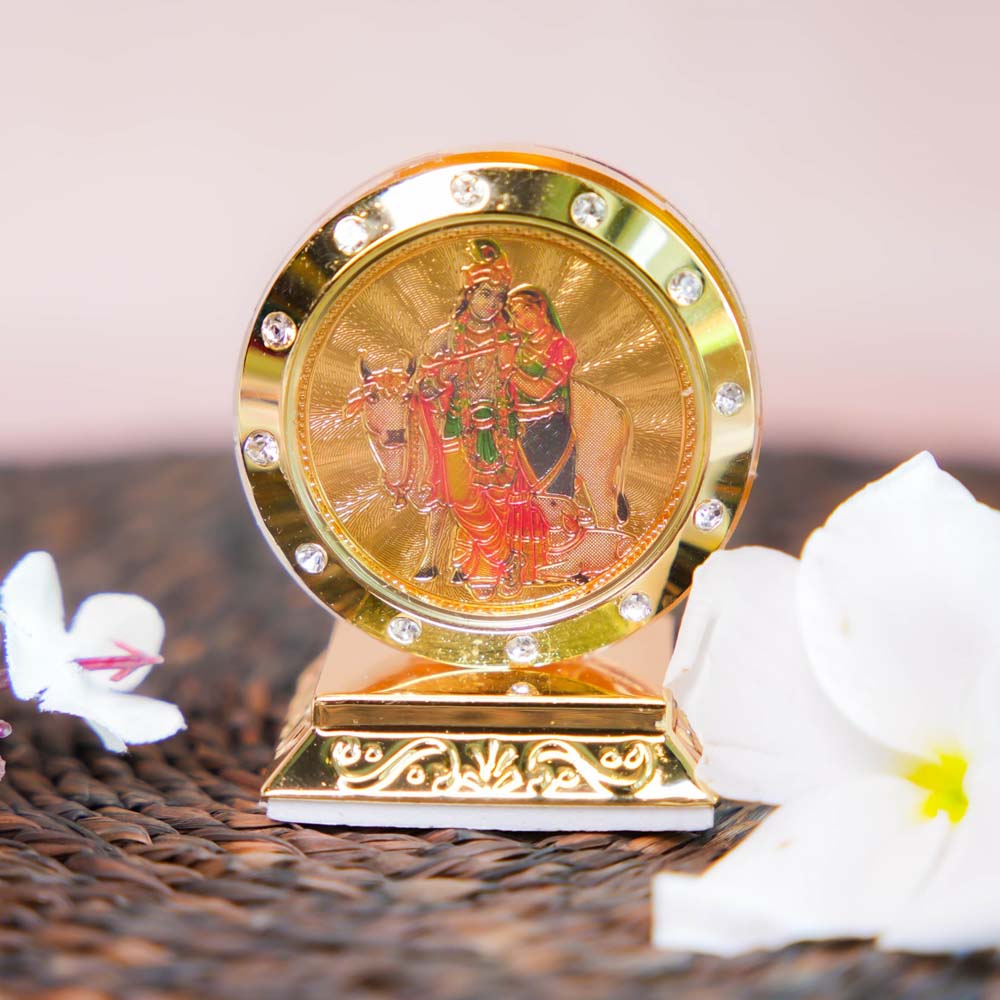 Radha Krishna Car Dashboard Stand with Golden Frame, Embedded Crystals, and Vibrant Depiction of the Divine Couple.