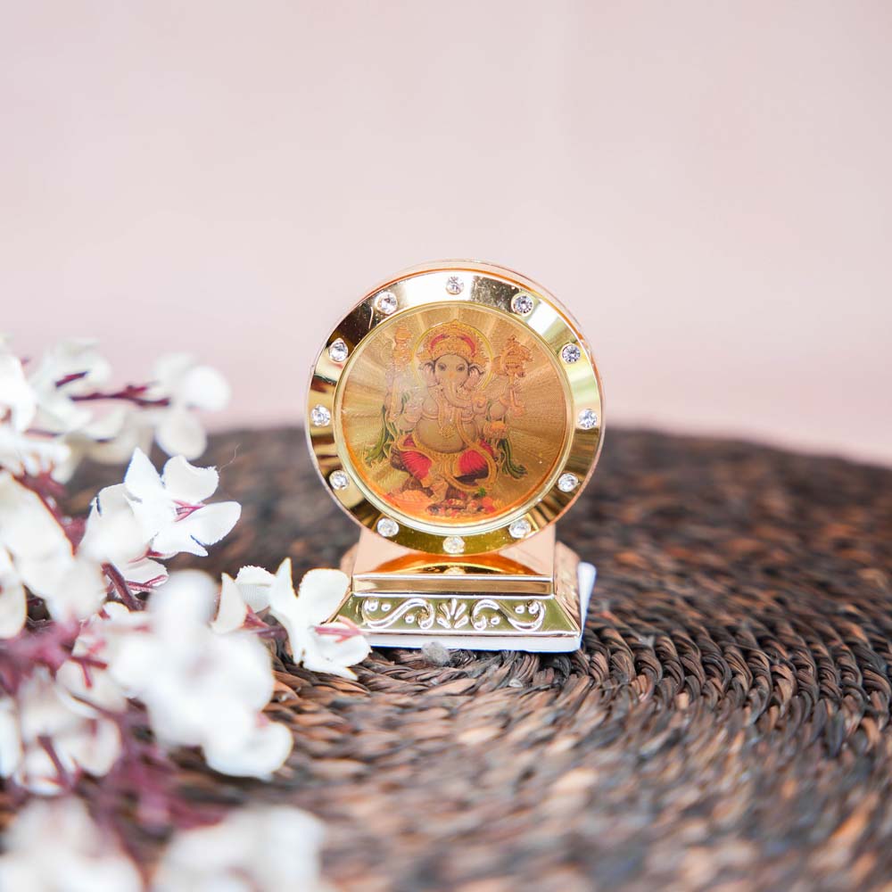 Golden Ganesha Car Dashboard Stand with Embedded Crystals and a Vibrant Image of Lord Ganesha.