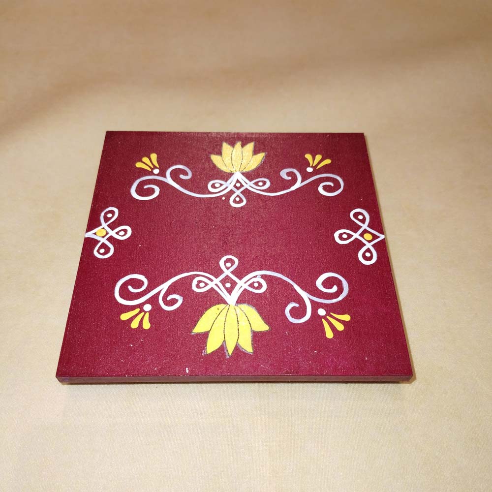 Maroon Kolam Manai platform with a red kolam design, used for traditional pooja and rituals.