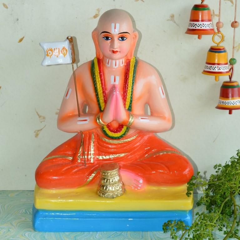 Handcrafted Navarathri Golu doll of Saint Ramanujar in a meditative posture, holding a flag and adorned with vibrant details.