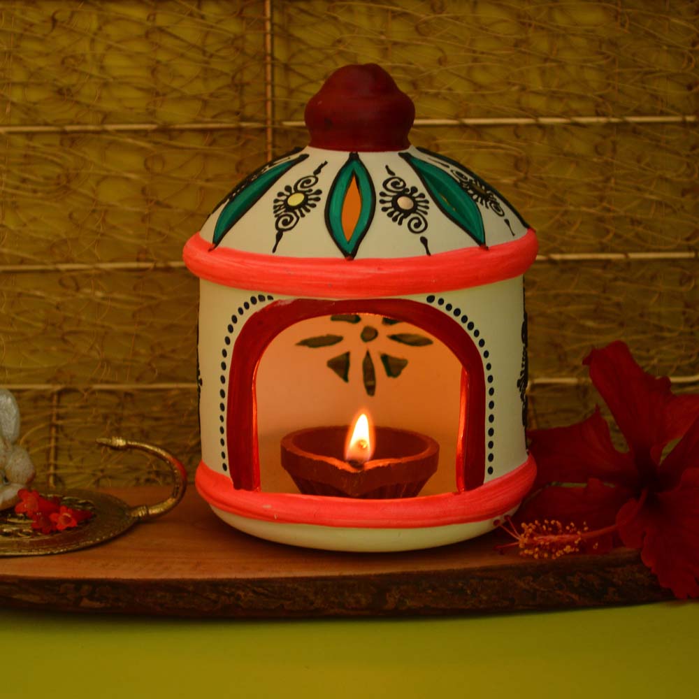 Handcrafted earthen round hut lamp holder with vibrant colors and intricate detailing, featuring a lit clay lamp inside.