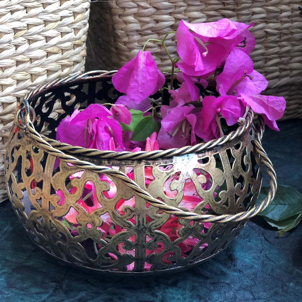 Antique-finish metal filigree lantern pot with intricate cutwork design, holding vibrant pink flowers.