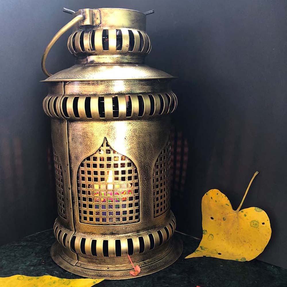 Antique gold metal Taj-inspired lantern with intricate perforated design, casting warm light.