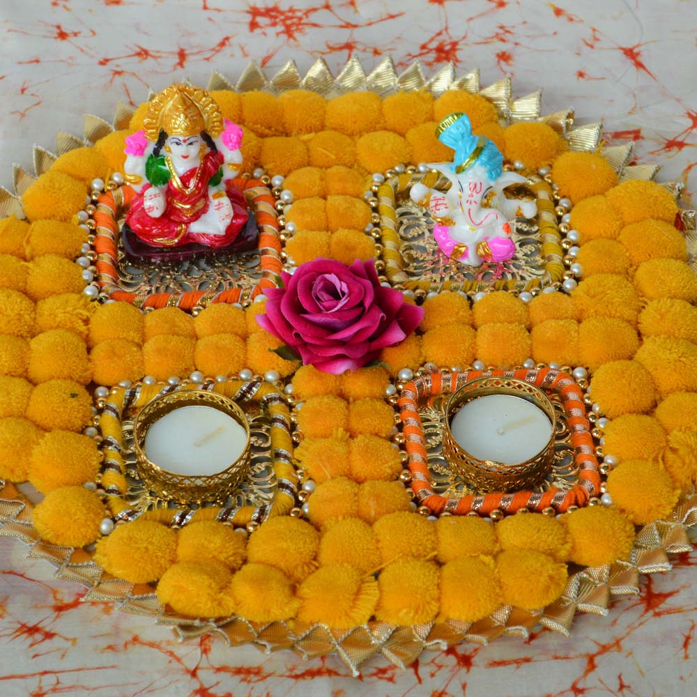 Fancy Lakshmi Ganesh Pom Pom Floor T-Light Decoration with yellow pom-poms, golden T-light holders, and pink floral accents.
