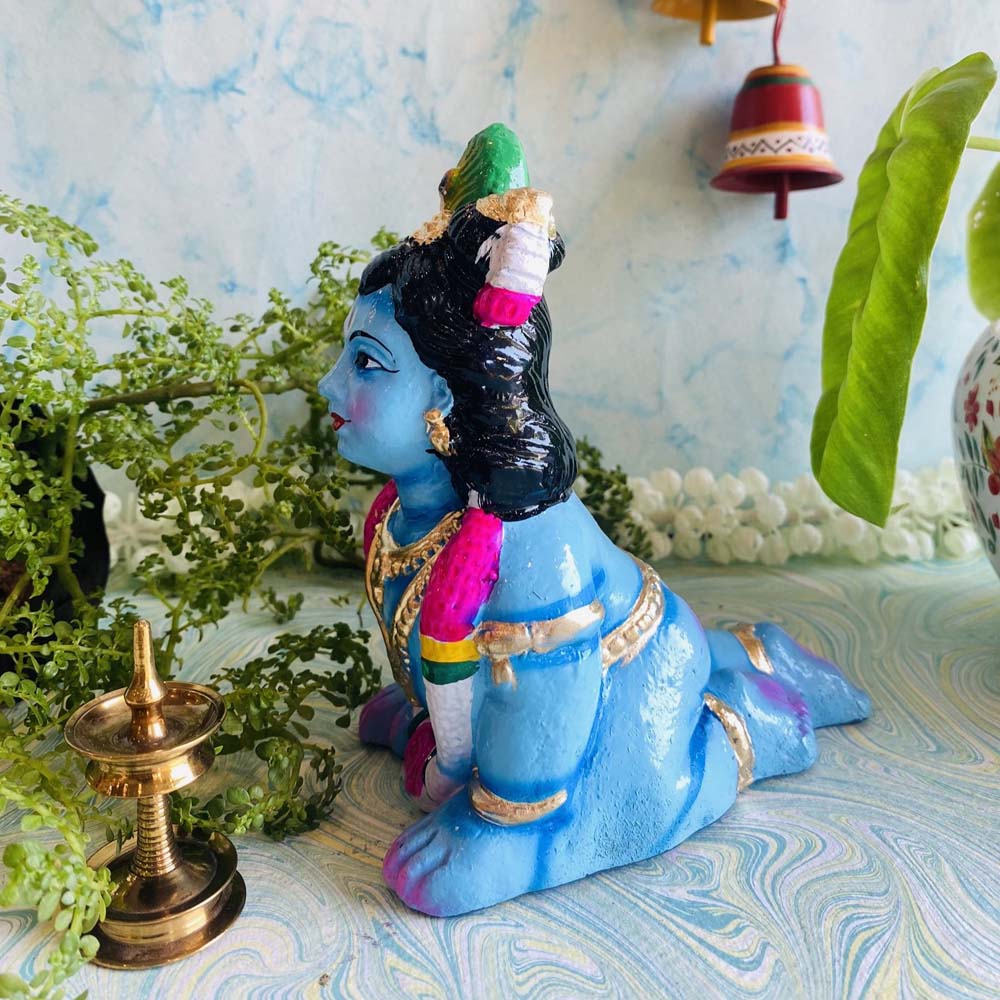 Handcrafted small infant Krishna idol in a crawling pose, vibrant blue with ornaments, for Navaratri Golu.