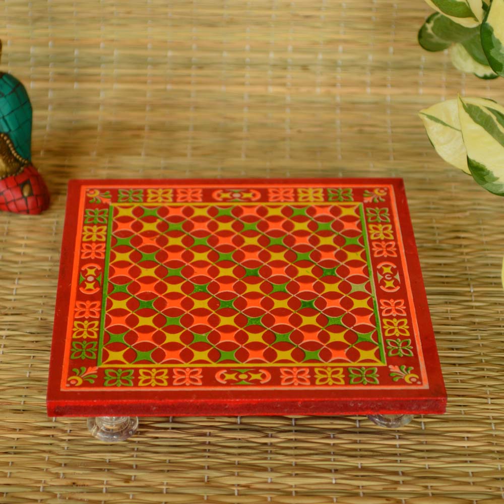 Wooden puja stool with floral design and transparent acrylic feet.
