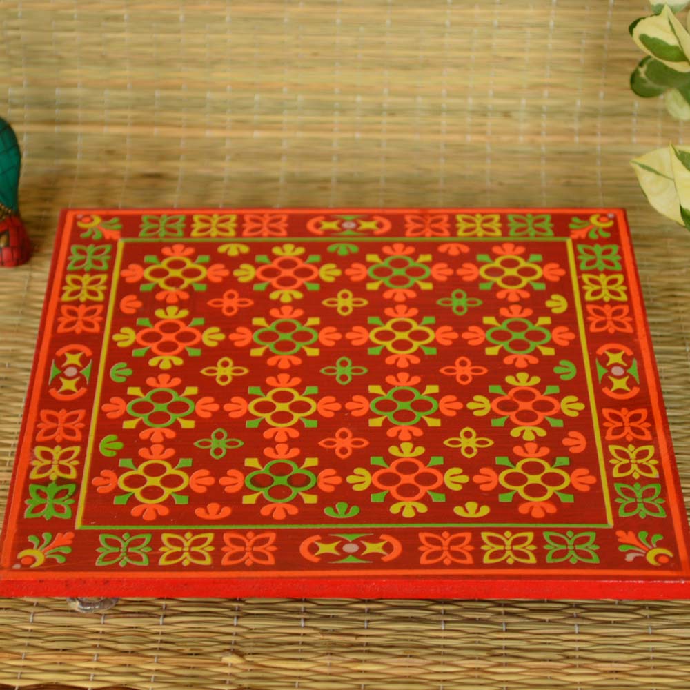 Wooden puja stool with colorful flower design and transparent acrylic feet.