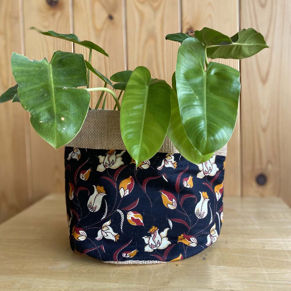 Natural jute plant holder with a vibrant floral lotus print, ideal for indoor or outdoor use, featuring a rustic yet elegant design.