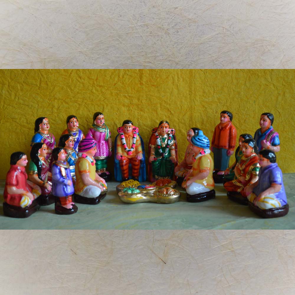 Handcrafted Navaratri Golu doll set depicting a traditional South Indian engagement ceremony (Nichayathartham) with bride, groom, and family members.
