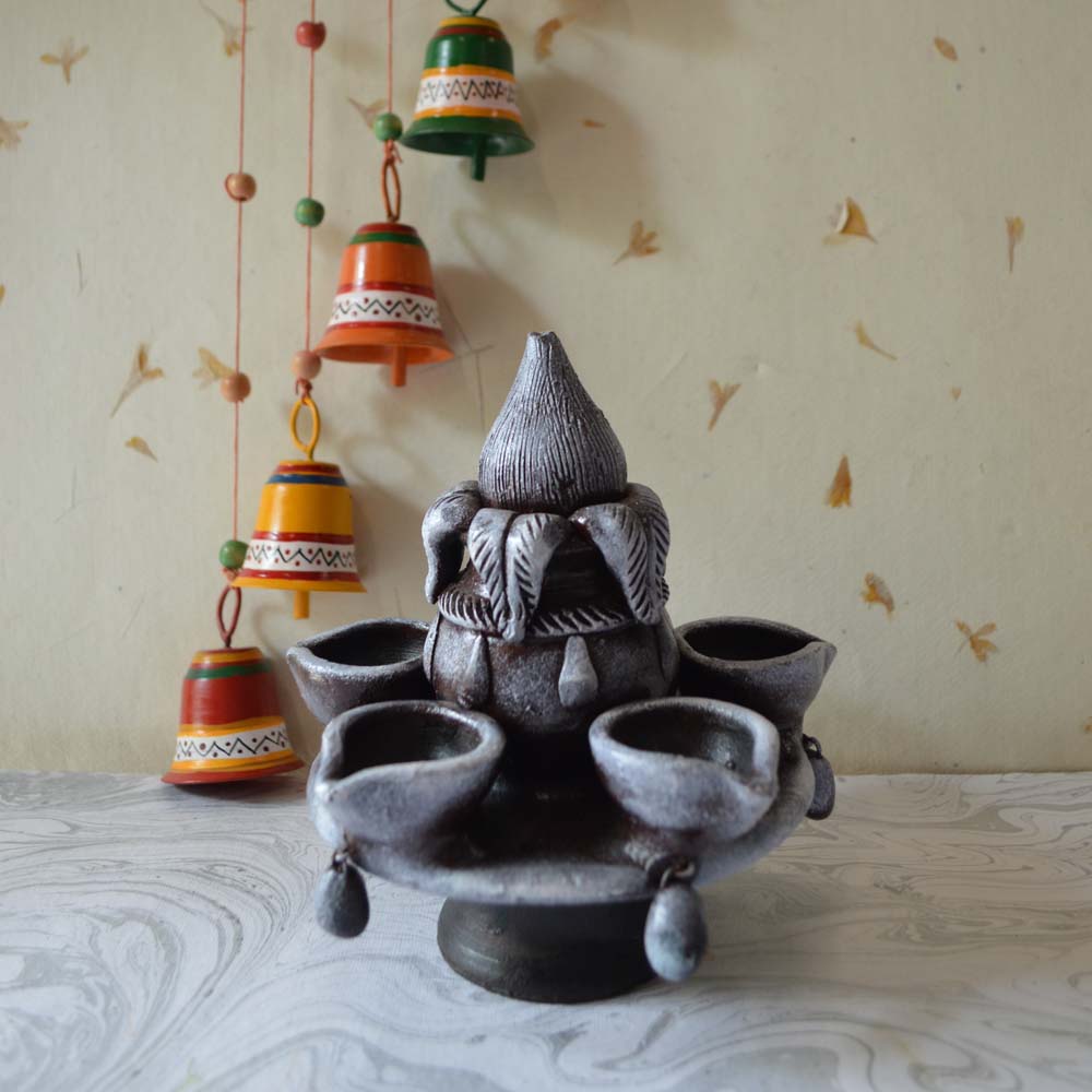 Traditional Kumban lamp with intricate detailing, a rustic finish, and multi-tiered oil holders.