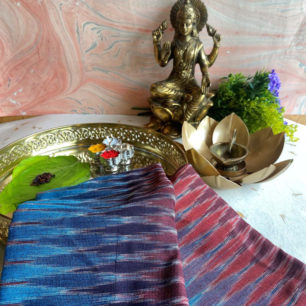 Pochampalli fabric in sky blue and red zigzag pattern, handwoven with a cotton blend, displayed with traditional decor.