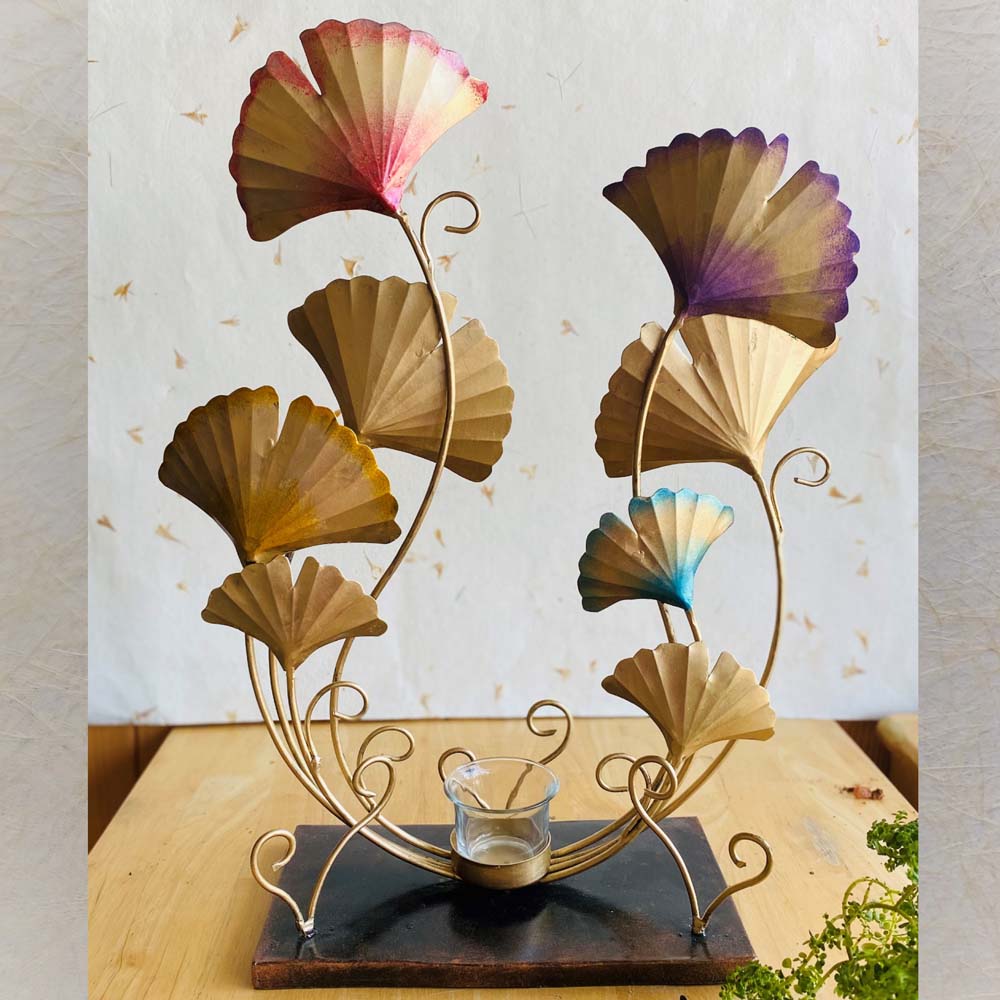 Handcrafted metal Ginkgo leaf T-light holder with gold finish and multicolor accents, featuring an elegant design and a central candle holder.