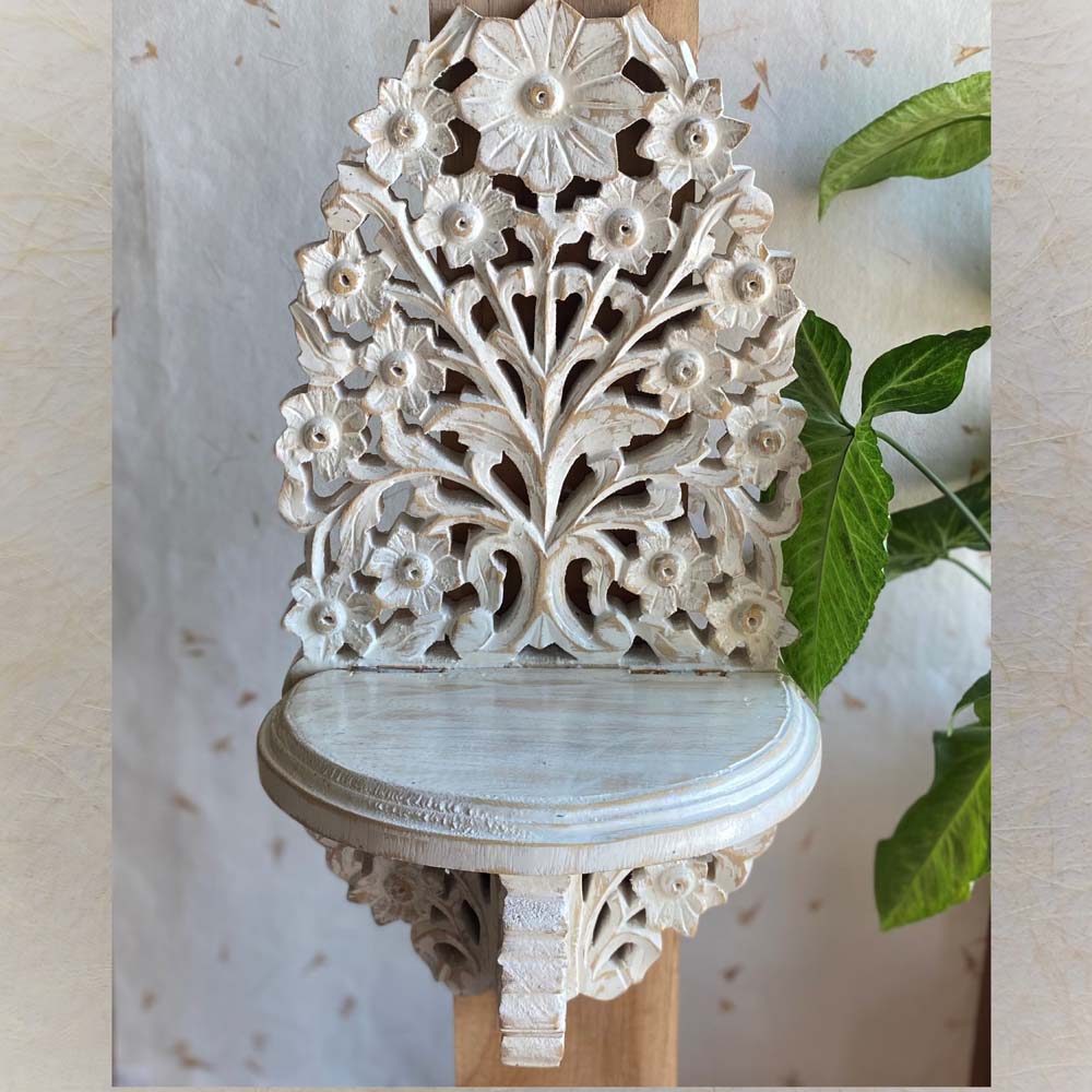 Handcrafted wooden wall bracket with intricate blooming flower carvings in a distressed white finish.