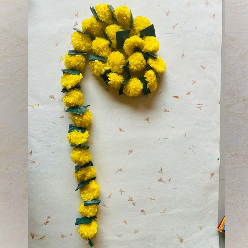 Yellow single-string garland with folded green leaves, perfect for festive and traditional Indian decor.