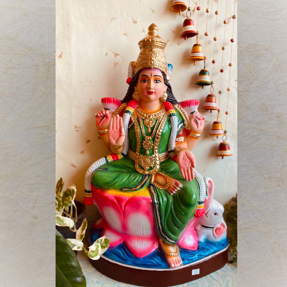 Handcrafted Navarathri Golu Doll depicting Goddess Lakshmi seated on a lotus, painted in vibrant colors, with intricate detailing and jewelry.