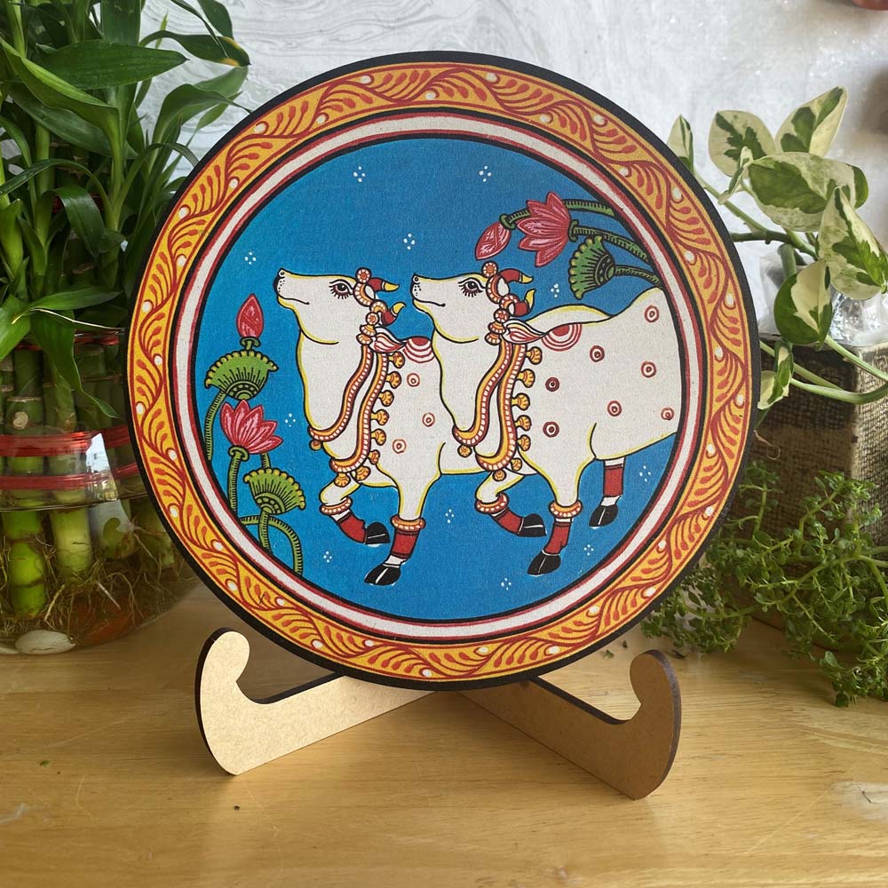 Decorative Circular Wall Art Featuring Two Sacred Cows on a Blue Background with Floral Motifs