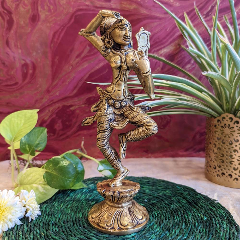 Intricate brass figurine of a dancing lady holding a mirror, handcrafted for traditional decor and gifting.
