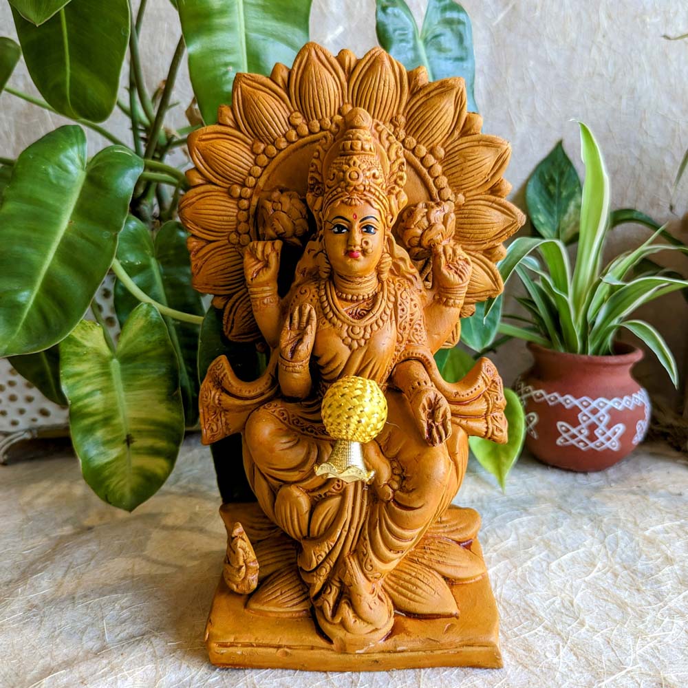 Handcrafted terracotta idol of Goddess Lakshmi seated on a lotus, showcasing traditional detailing and earthy tones.