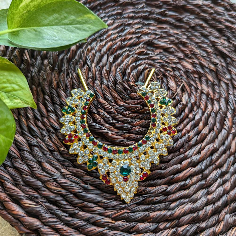 Traditional Jadai Billai with red, green, and white stonework on a woven brown background.