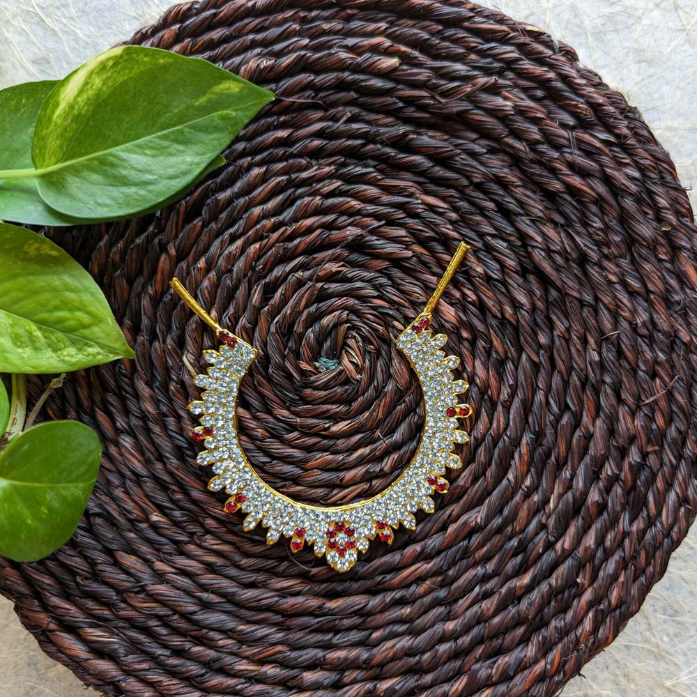 Traditional Jadai Billai with red and white stonework on a woven brown background.