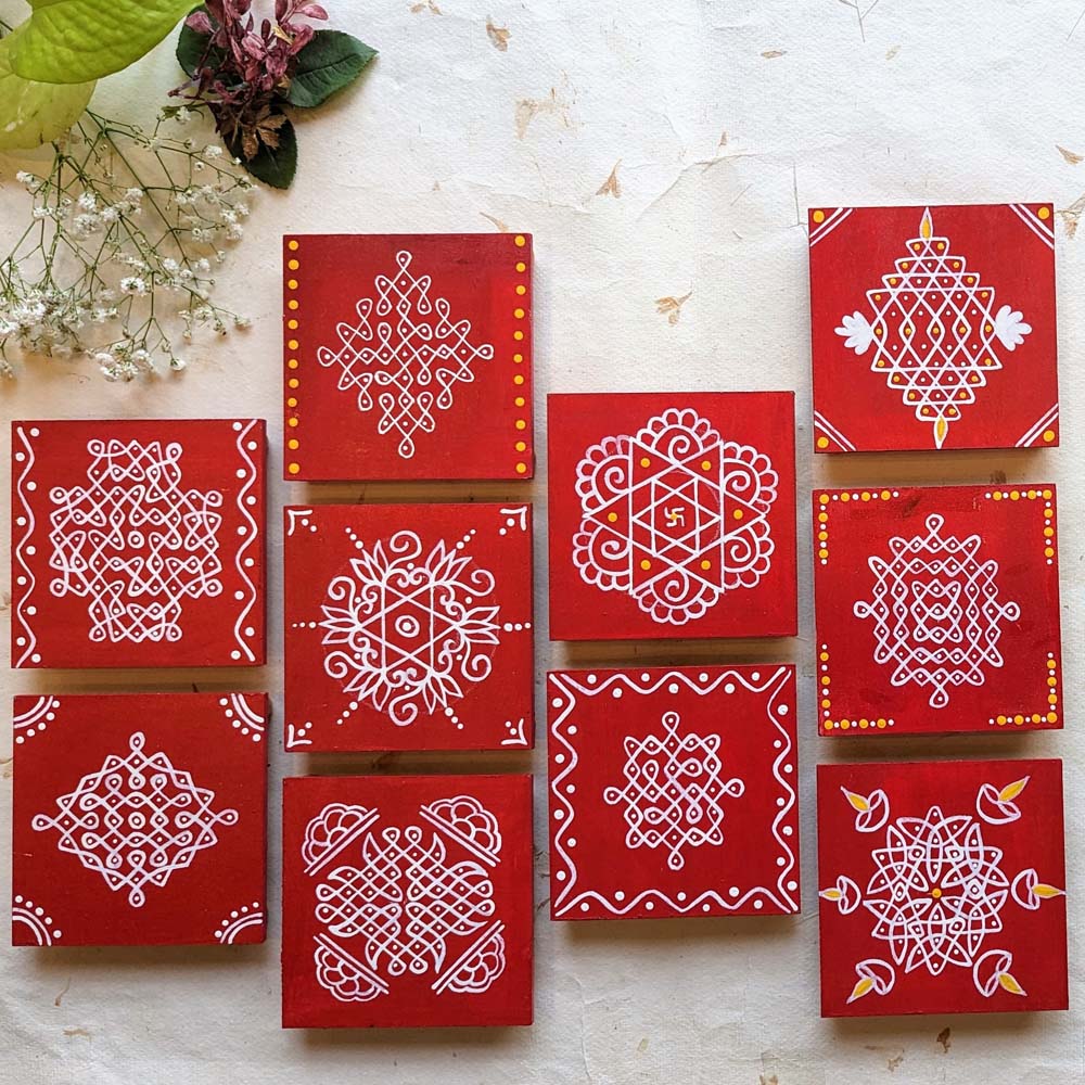 Bright red wooden manai set with traditional white kolam designs and yellow accents, arranged against a soft decorative background.