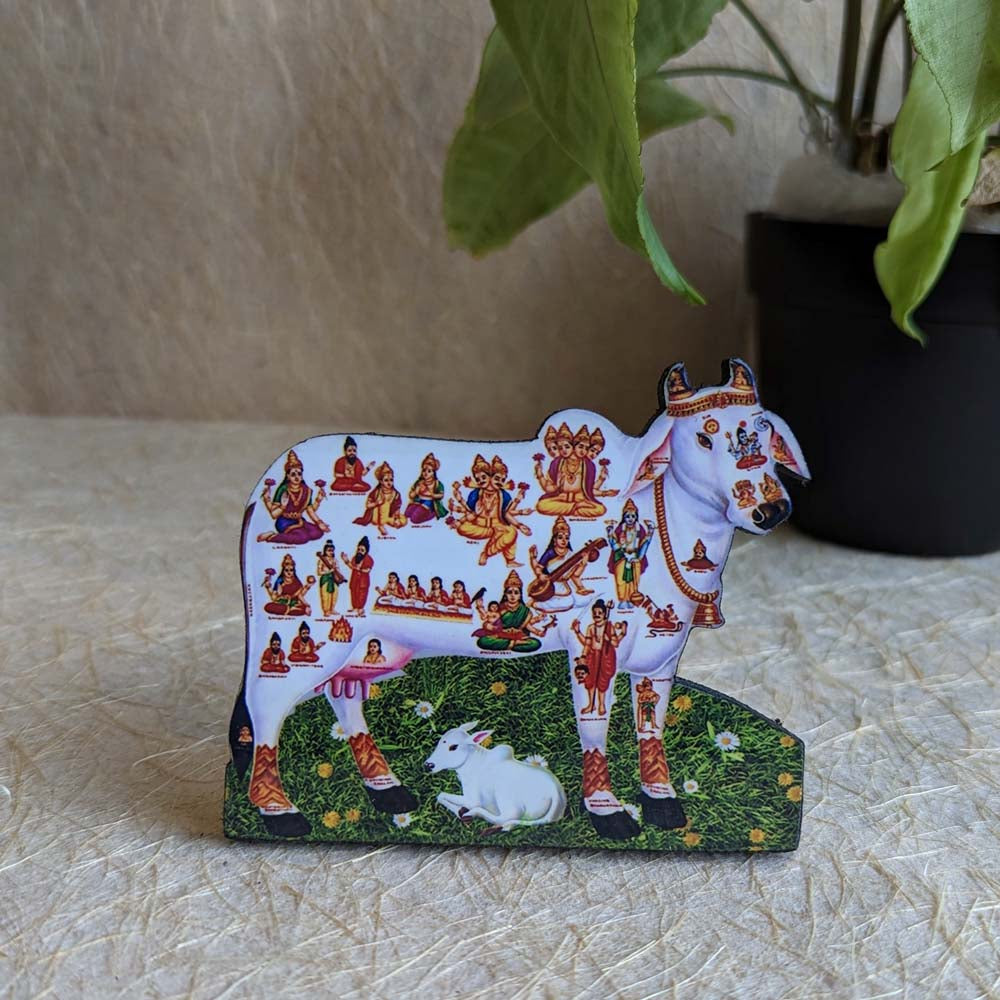 Kamadhenu decorative tabletop stand featuring the sacred cow with deities, ideal for pooja rooms and spiritual decor.