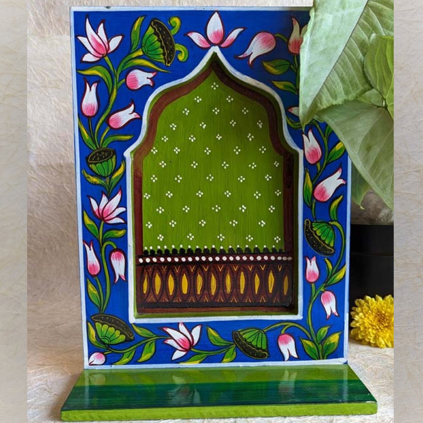 Hand-painted wooden wall shelf with vibrant blue and green tones, featuring lotus flower motifs and a traditional arched design.