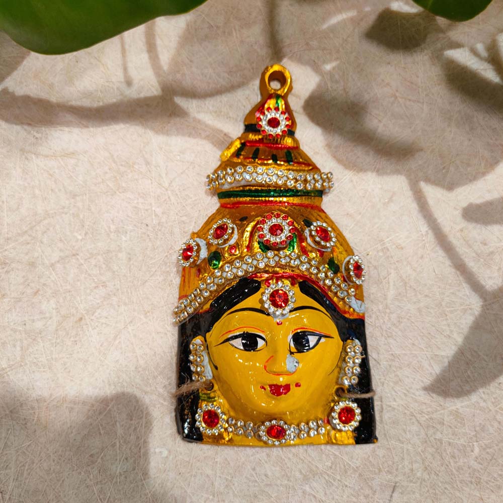 Handcrafted Amman Face wall decor in vibrant yellow with a jeweled crown and intricate detailing.