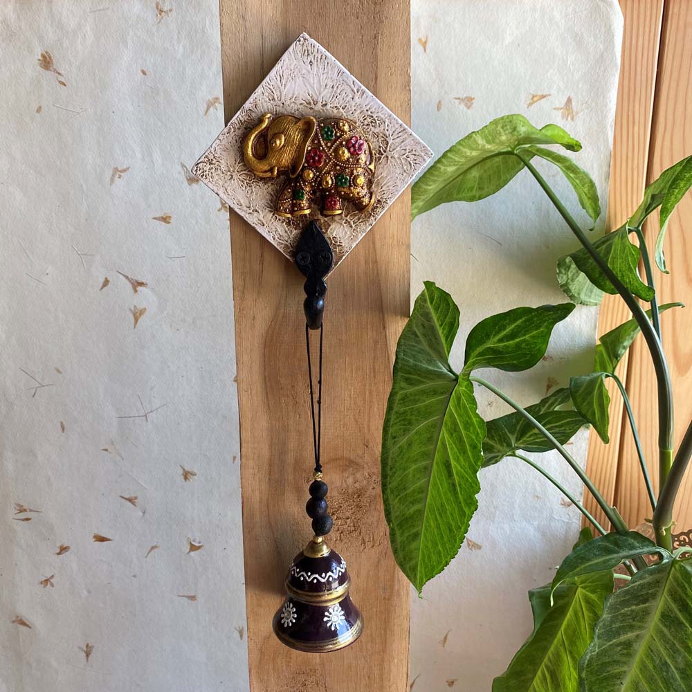 Handcrafted white key holder with a golden embellished elephant motif and a hanging decorative bell.