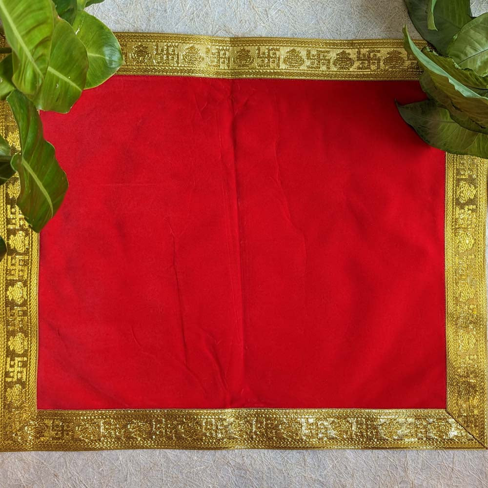 Red velvet pooja aasan with gold ornamental border and traditional motifs, ideal for prayer rituals.