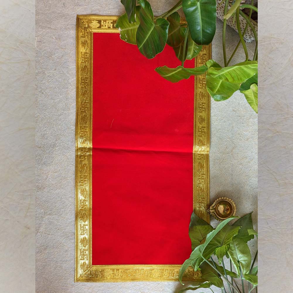 This luxurious red velvet Aasan with an ornate gold border is an ideal addition to your pooja setup. Crafted with high-quality velvet fabric, the Aasan is soft to touch and features a golden brocade border adorned with auspicious motifs, adding elegance to your sacred rituals. Perfect for deity seating, kalash placement, or as a pooja mat, this Aasan enhances the spiritual ambiance of your space.