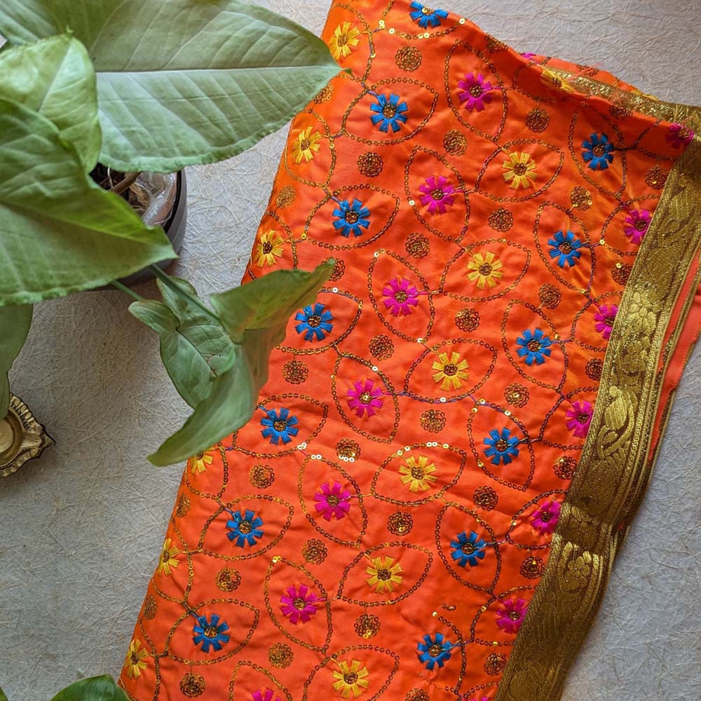 Orange Chunari with multicolored floral embroidery and a gold border, perfect for puja rituals and festive decorations.