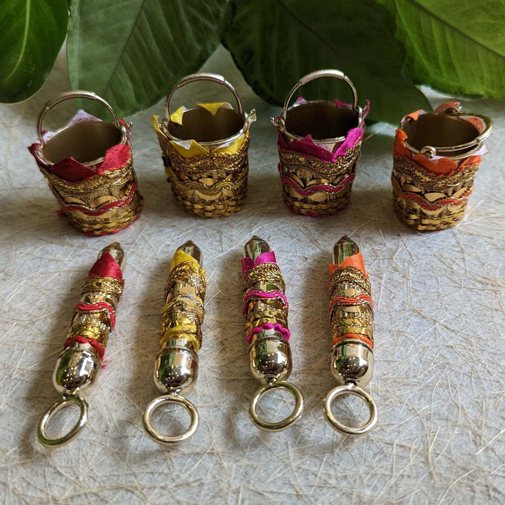 Miniature Holi Pichkari and bucket set with colorful designs and intricate festive embellishments, perfect for decor and gifting.