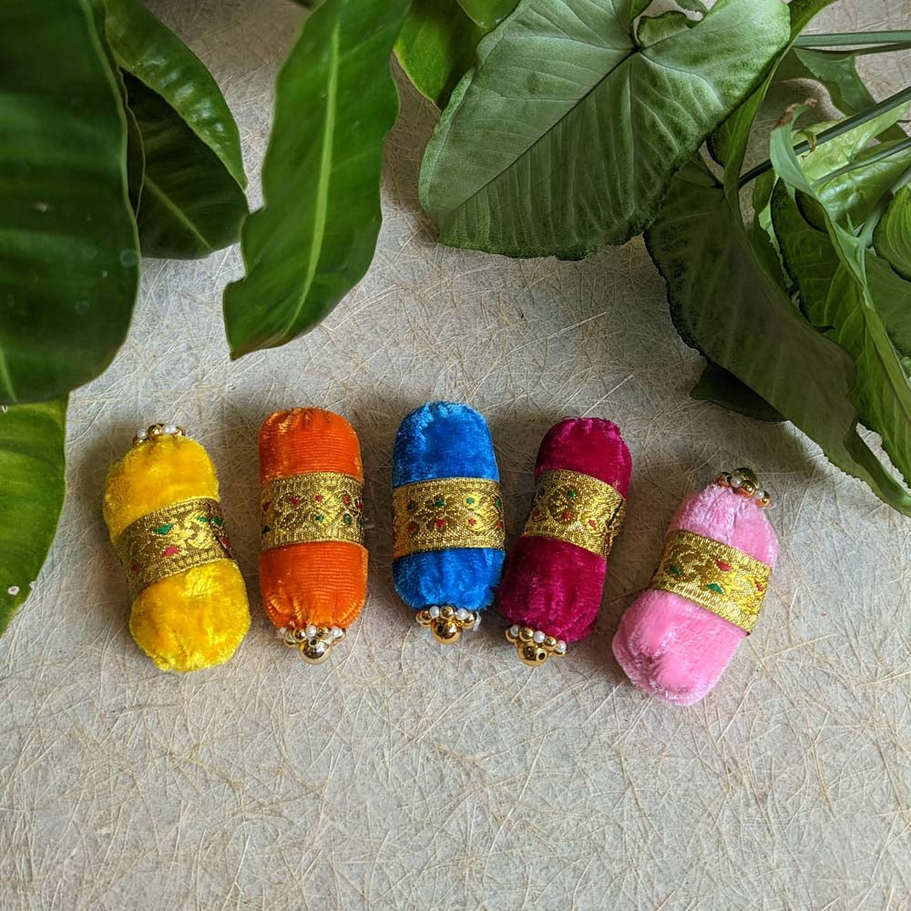 Set of five vibrant velvet deity bolsters with gold-tone embellishments and beadwork.
