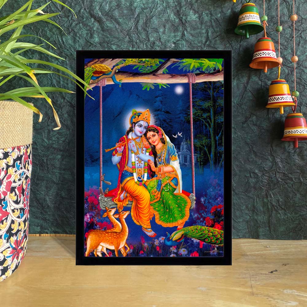 Radha Krishna sitting on Jhula artwork with peacock, deer, and floral forest background, vibrant home decor.