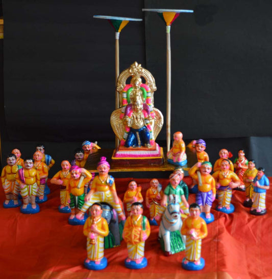 Traditional Navarathri Golu doll set featuring Lord Vishnu on Garuda, surrounded by devotees and musicians in a temple procession.