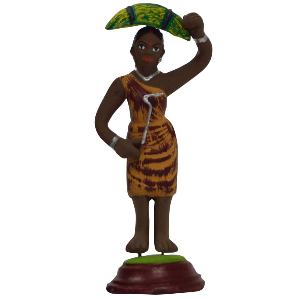 Handcrafted Miniature Tribal Woman Figurine in a patterned brown dress, carrying banana leaves on her head.